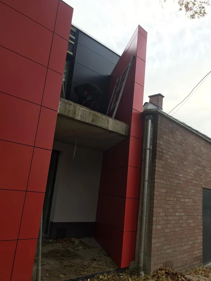 Bardage rouge en panneaux pendant les travaux de façade