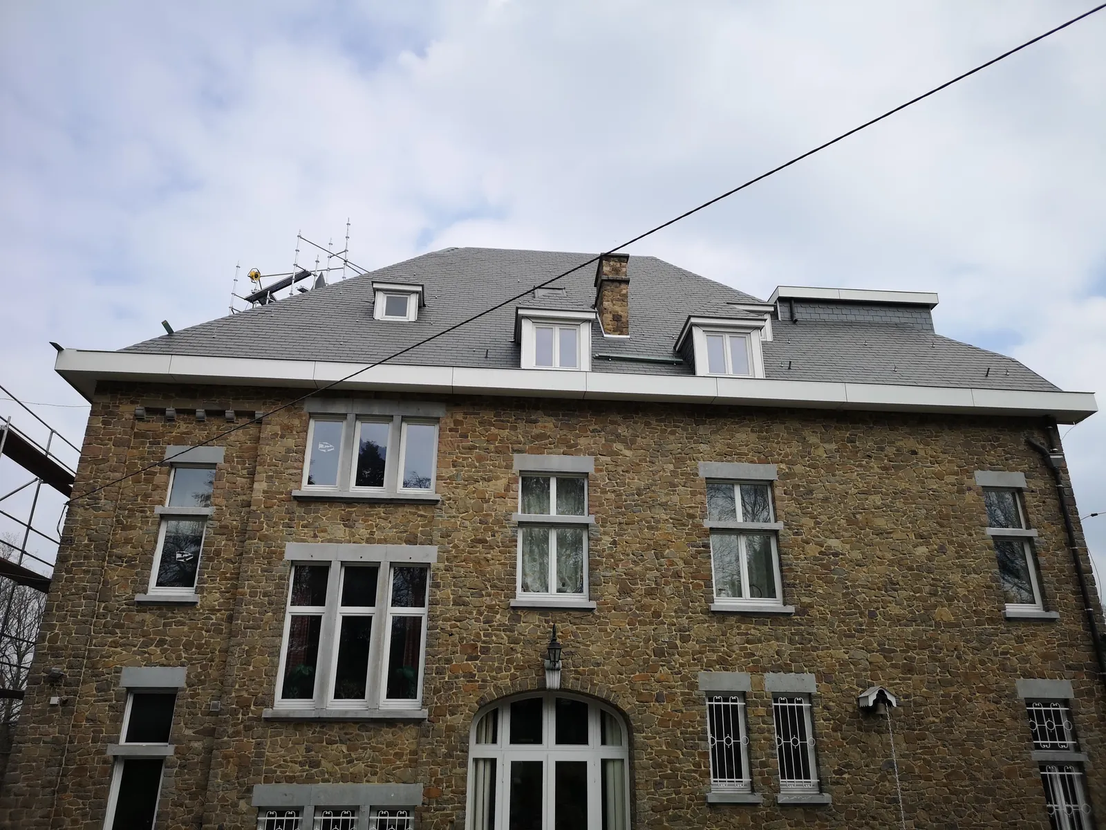 Toiture en ardoises rénovée sur une villa en pierre