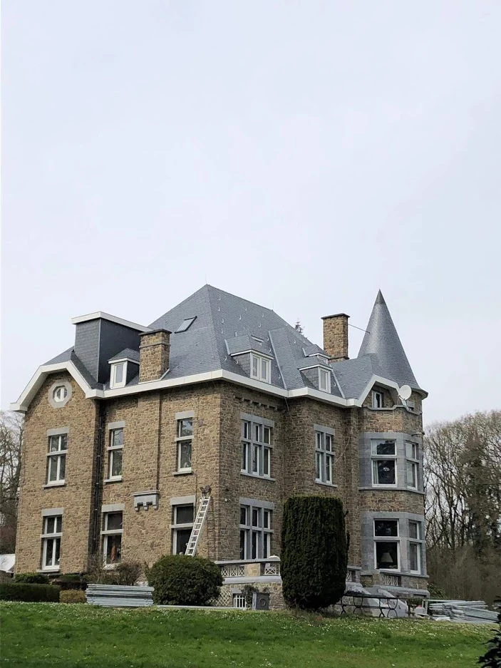 Villa en pierre, tourelle et couverture vues depuis le jardin