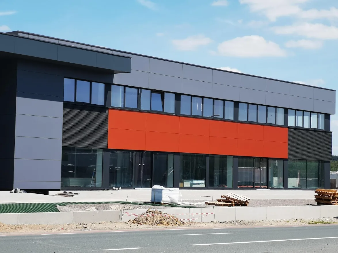 Bardage de façade commerciale avec panneaux rouges et gris