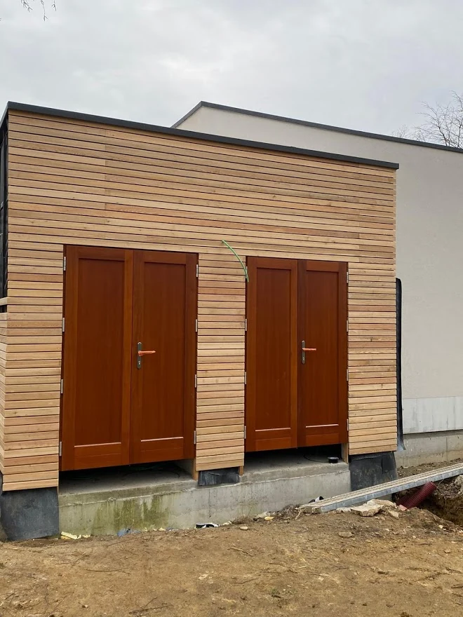 Façade de la même annexe bardée bois, avec ses deux portes