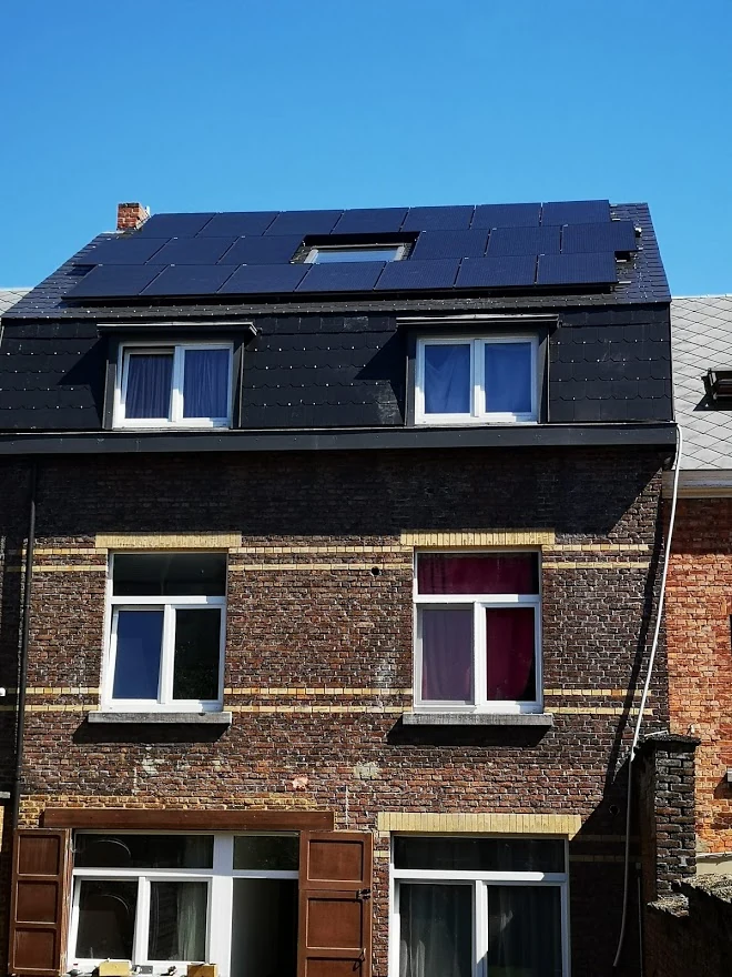 Toiture mansardée et deux lucarnes sur une maison de rangée
